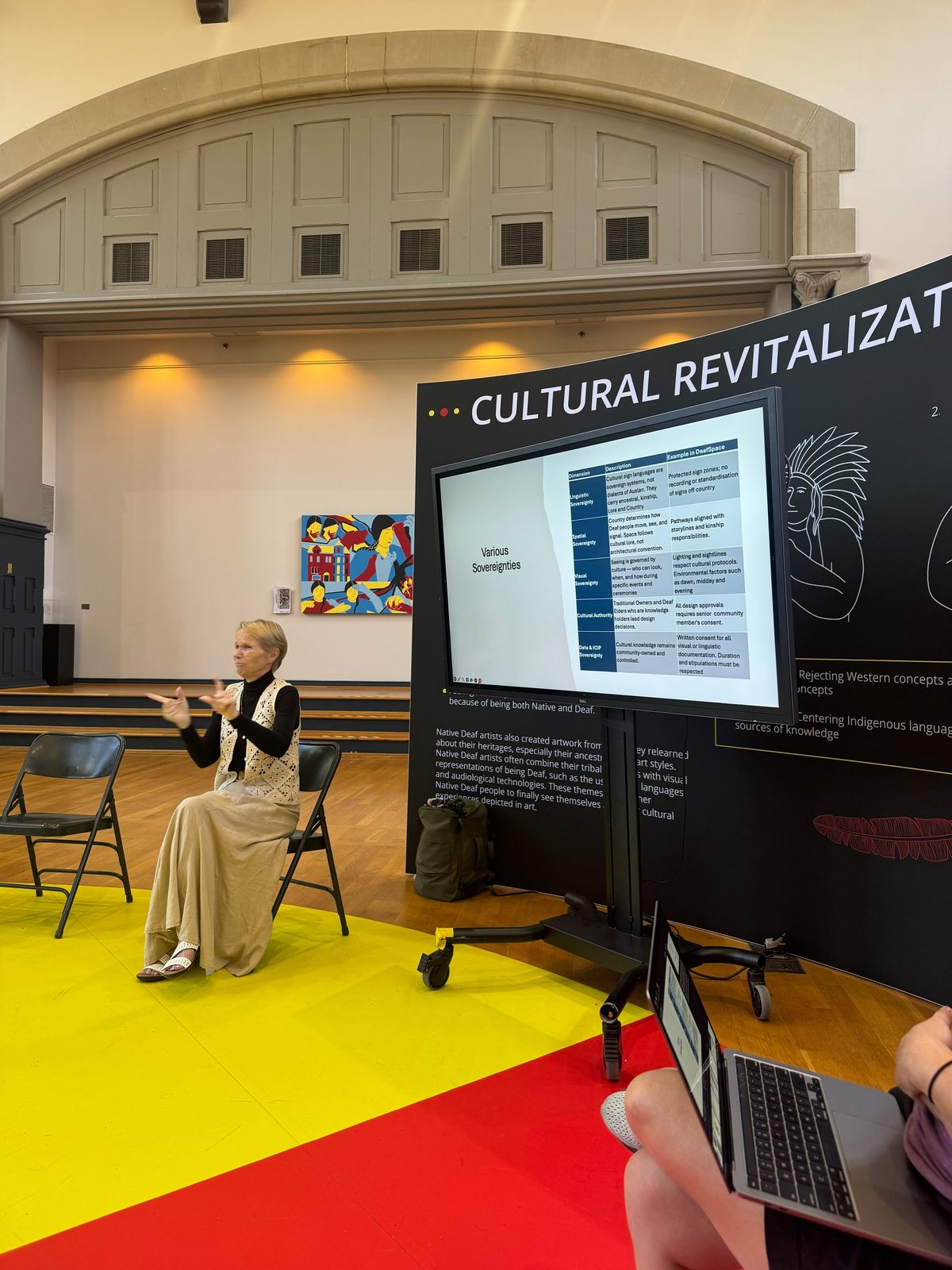 Jody presenting beside a Cultural Revitalization display
