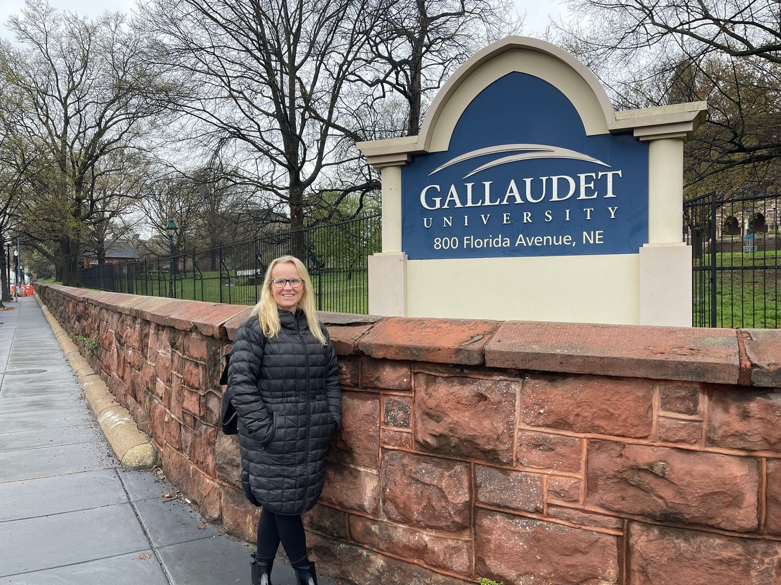 Jody beside the Gallaudet University sign